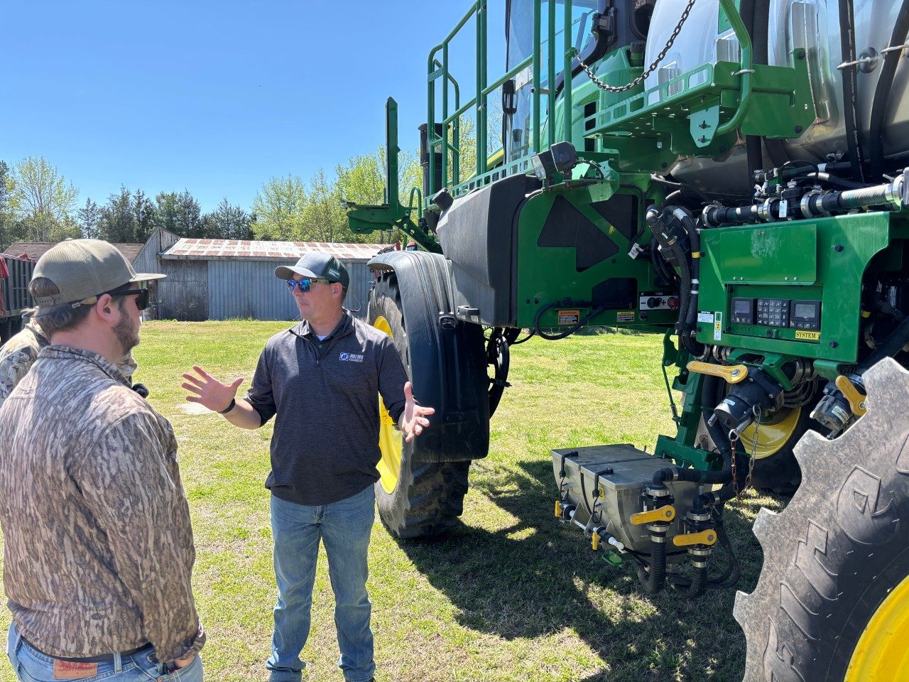 an industry speaker showing students a large spray rig in the field